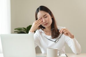 Young woman in Reading holds her eye, wondering about her glaucoma risk level