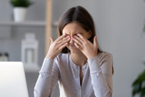 A woman with dry eye disease rubbing her eyes